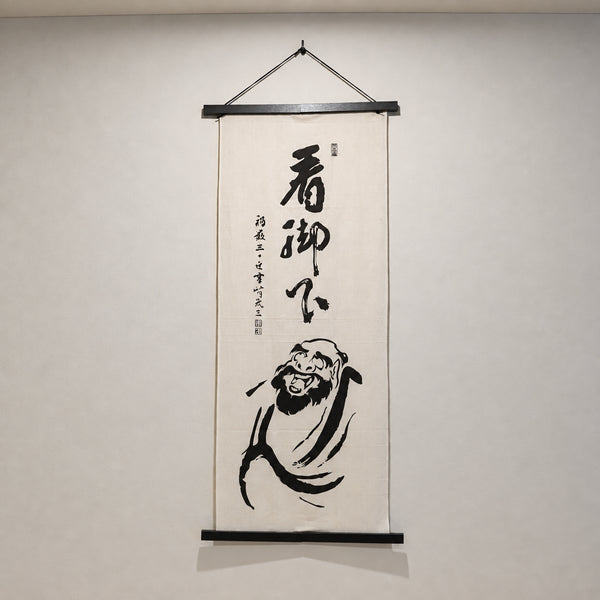 壁に飾った笑うダルマさん手ぬぐい